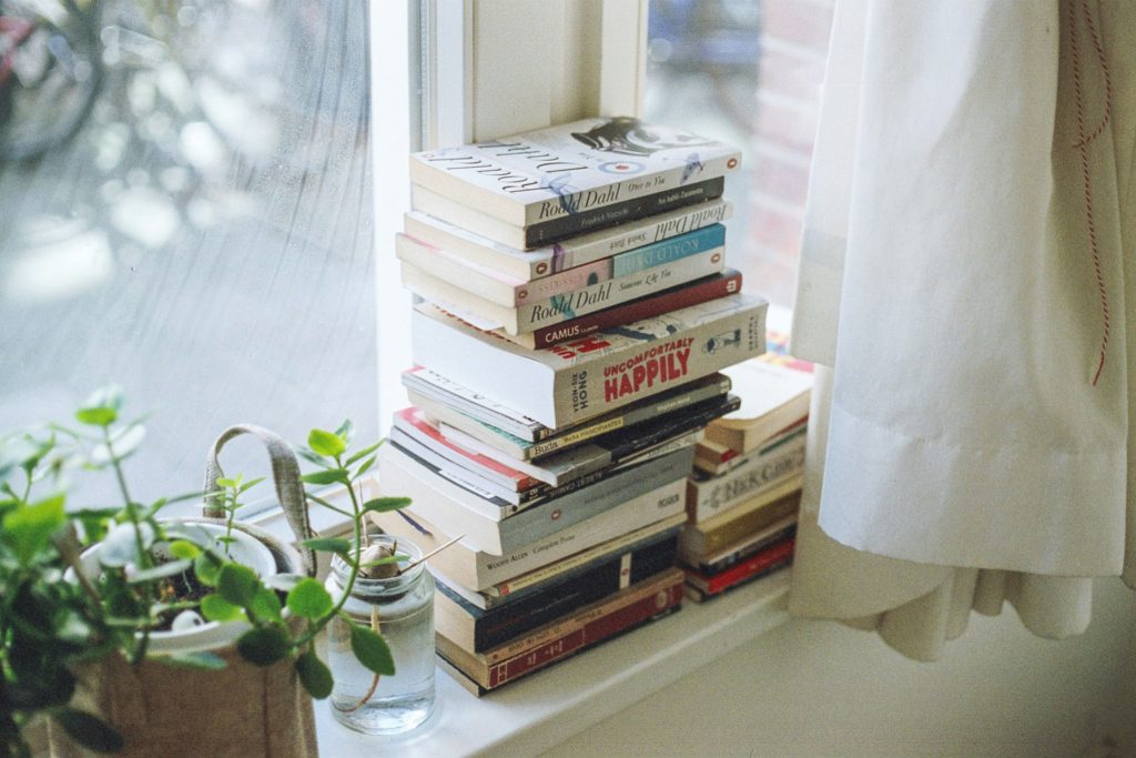Books stacked on a window sill.