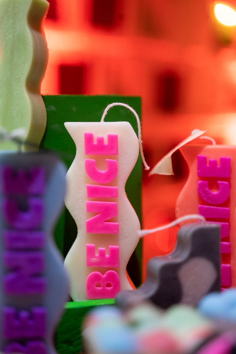 Vibrant candles with 'Be Nice' message in a colorful setting.