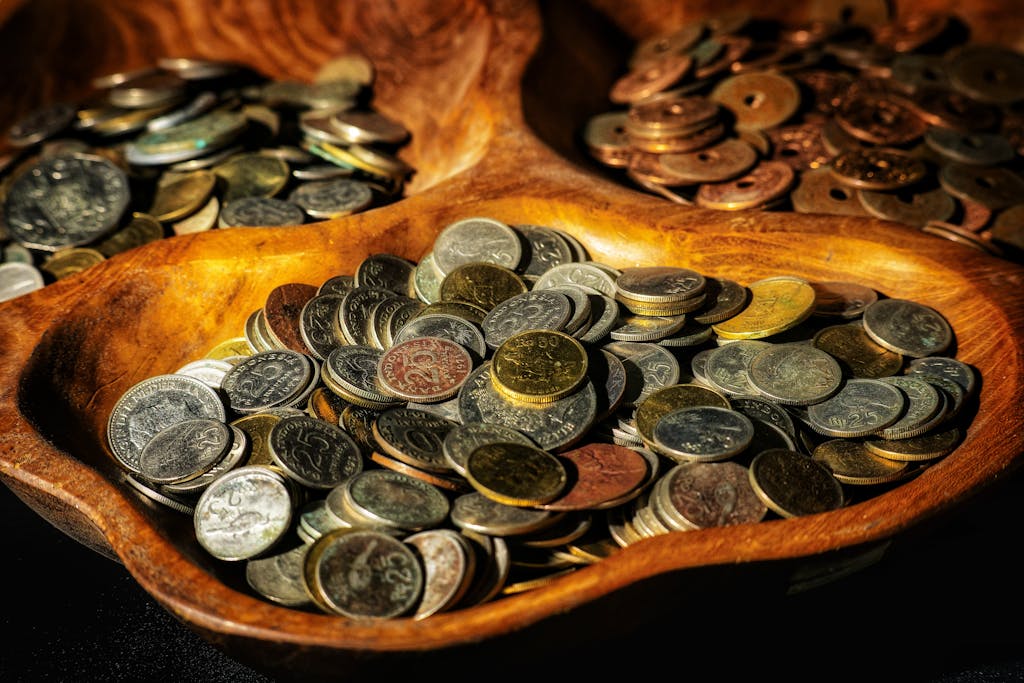 Coins of various denominations displayed in wooden bowls.